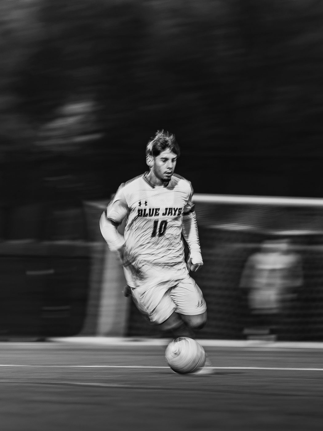 A soccer player dribbling, with BW